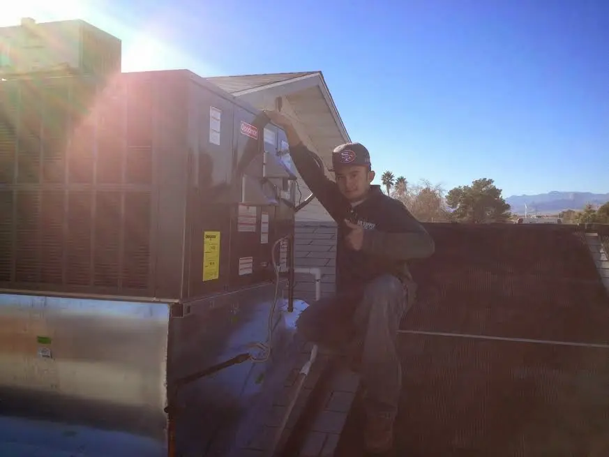 HVAC technician performing AC Tune-Up on a rooftop unit in Hampshire