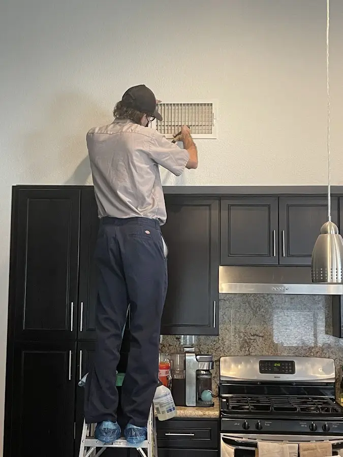 Technician inspecting an air vent during HVAC service in Hampshire